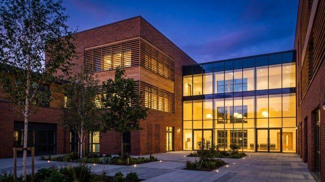 Contemporary UK school and multi-academy trust architecture at twilight